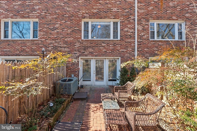 rear view of house featuring central air condition unit, fence, an outdoor hangout area, and french doors