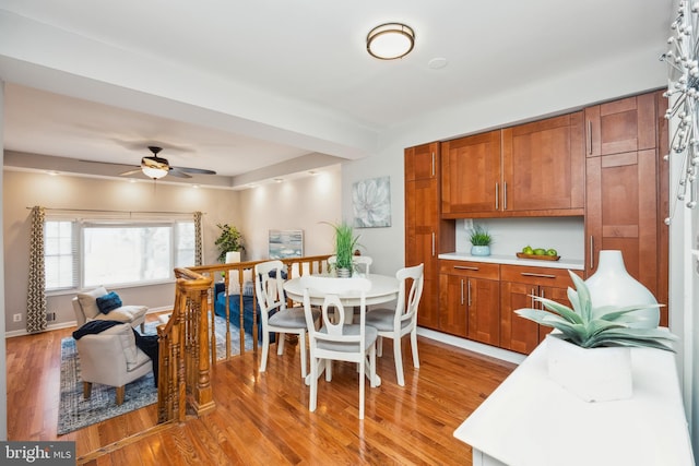 dining area featuring light wood-style flooring, baseboards, and a ceiling fan