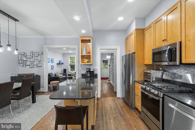 2652 Woodley Pl NW, Washington, DC 20008 - kitchen with appliances with stainless steel finishes, dark wood finished floors, a breakfast bar, decorative backsplash, and open floor plan
