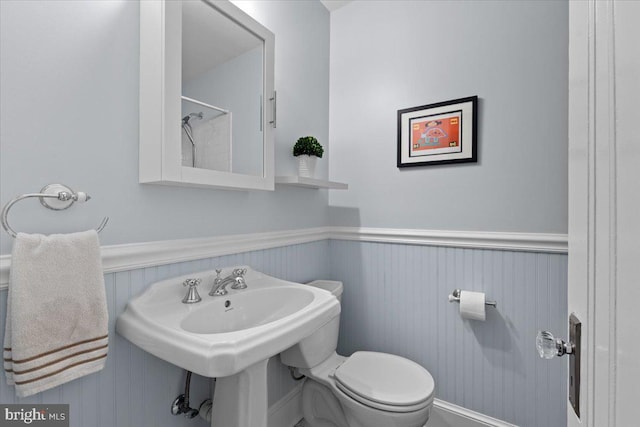 2652 Woodley Pl NW, Washington, DC 20008 - bathroom featuring a wainscoted wall, toilet, and a shower