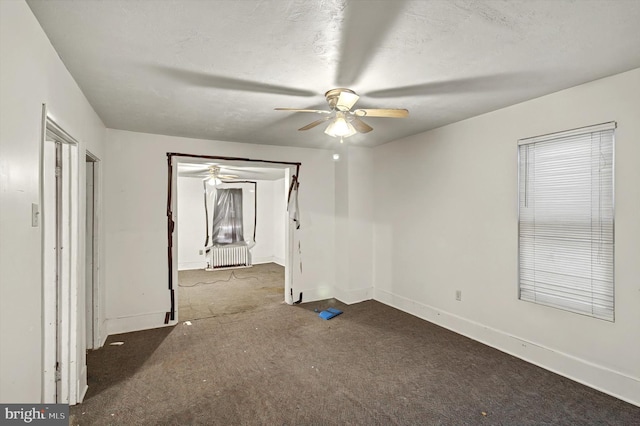 spare room featuring carpet, a textured ceiling, baseboards, and a ceiling fan