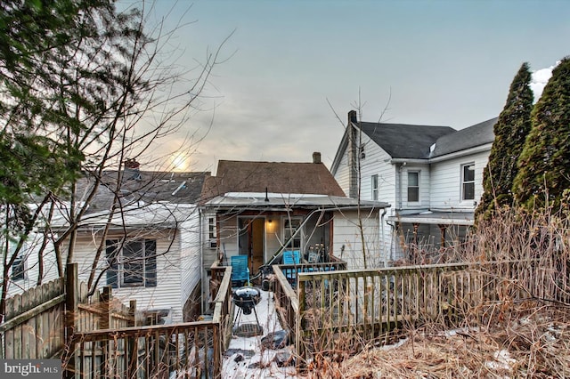 back of property featuring a chimney and fence