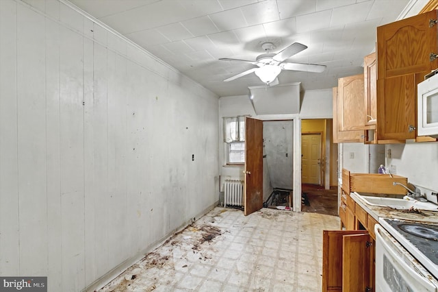 kitchen with white microwave, a sink, brown cabinets, light floors, and radiator heating unit