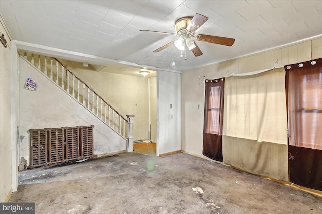 interior space featuring ceiling fan and stairway