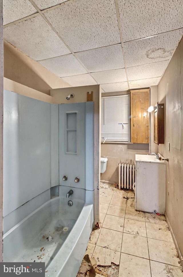 full bathroom featuring bathing tub / shower combination, radiator heating unit, tile patterned floors, vanity, and a paneled ceiling