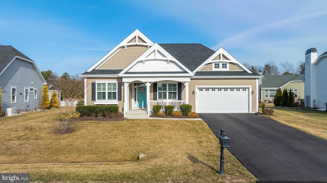 craftsman-style home featuring driveway, covered porch, a garage, and a front yard