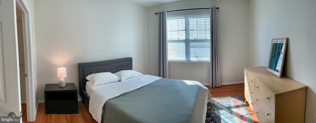 bedroom with light wood-type flooring and baseboards