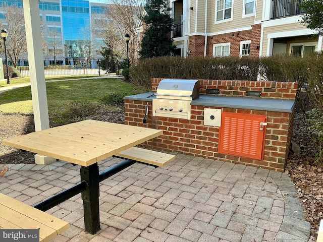 view of patio / terrace featuring an outdoor kitchen, fence, and grilling area