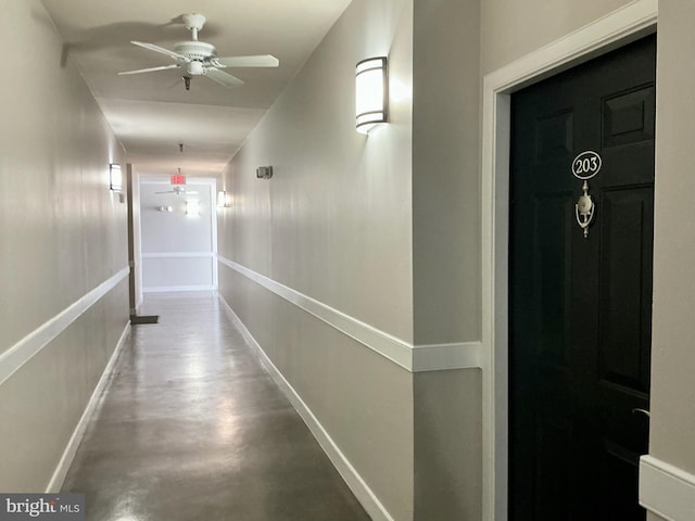 hall with concrete floors and baseboards