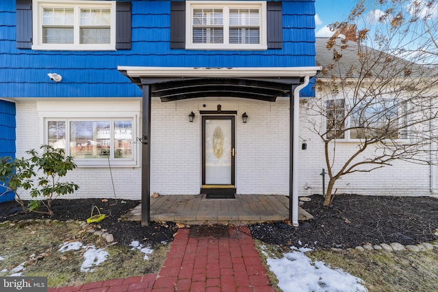 entrance to property with brick siding and mansard roof