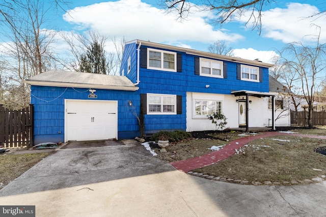 view of front of home with fence, driveway, and an attached garage