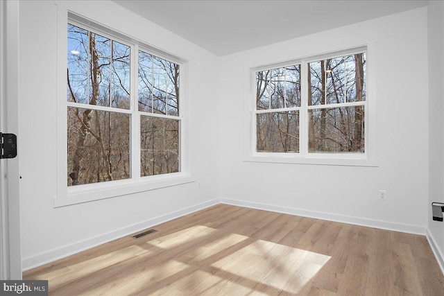 interior space featuring light wood-style floors, baseboards, and visible vents