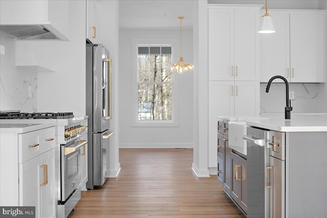 kitchen with decorative backsplash, appliances with stainless steel finishes, ventilation hood, and light countertops