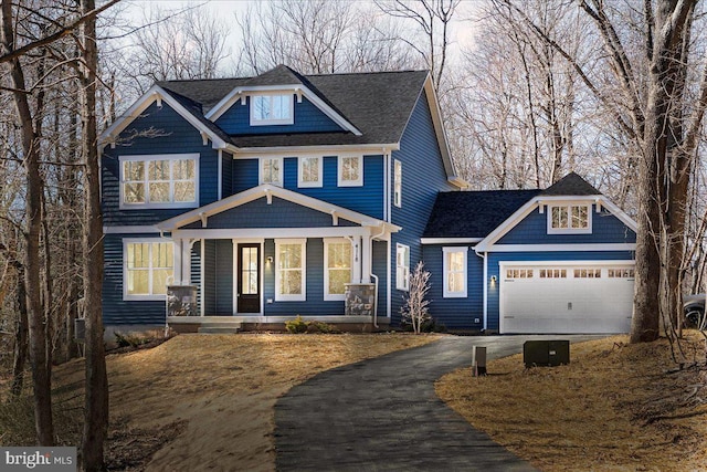 craftsman house featuring driveway, covered porch, an attached garage, and a shingled roof