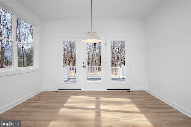 unfurnished dining area with baseboards and wood finished floors