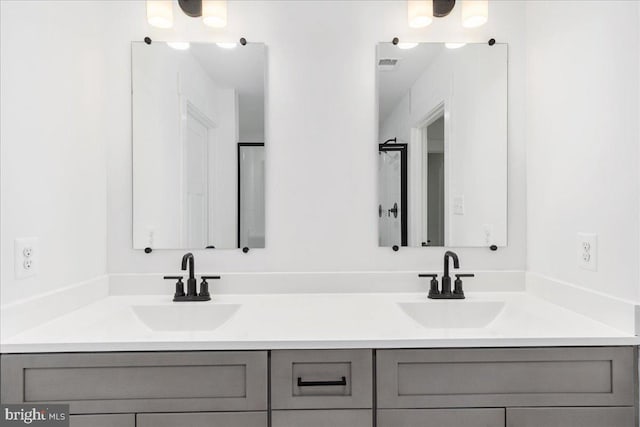 bathroom featuring double vanity, visible vents, and a sink