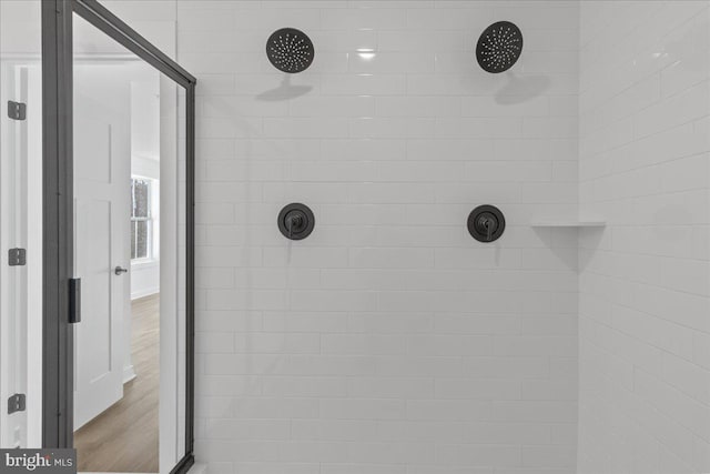 bathroom featuring a tile shower and wood finished floors