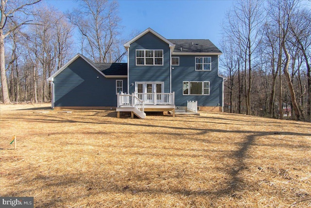 rear view of house featuring a yard and a wooden deck