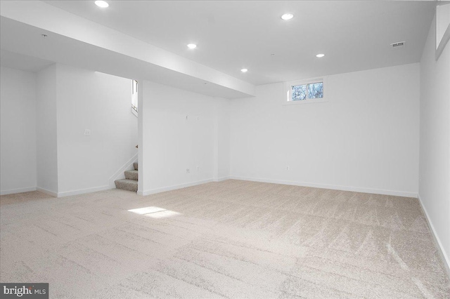 basement featuring baseboards, visible vents, stairs, carpet flooring, and recessed lighting