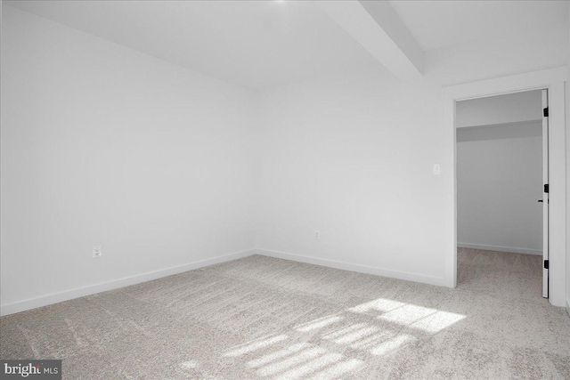 spare room featuring carpet floors and baseboards