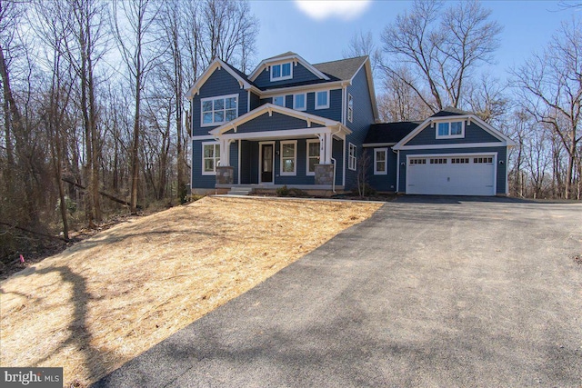 craftsman-style home with a garage, covered porch, and driveway