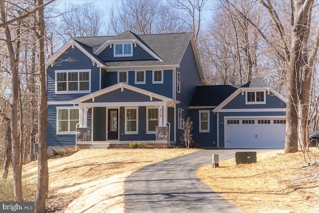 view of front of property featuring driveway, a shingled roof, a garage, and a porch