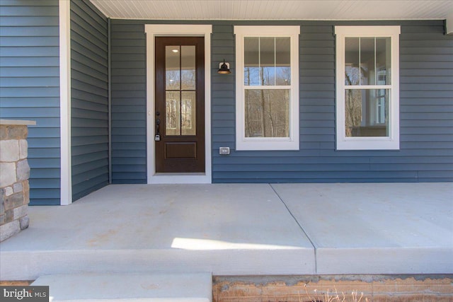 view of exterior entry featuring covered porch