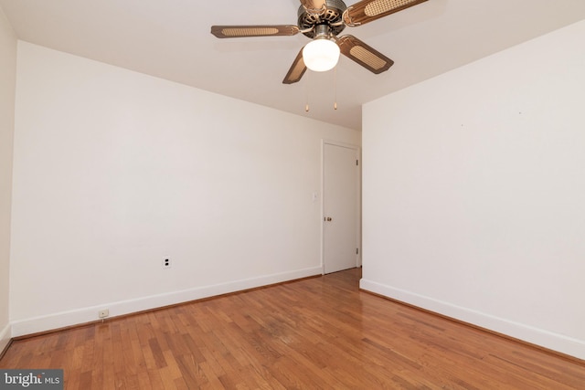 spare room featuring wood finished floors, a ceiling fan, and baseboards