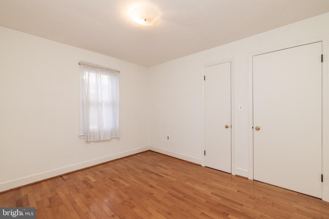 unfurnished bedroom featuring baseboards and wood finished floors