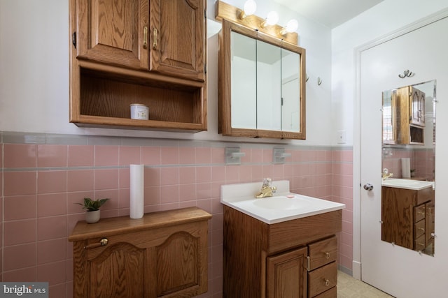 bathroom with a wainscoted wall, vanity, and tile walls