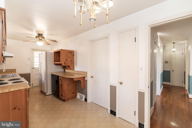 kitchen featuring dishwasher, light countertops, ceiling fan with notable chandelier, and freestanding refrigerator