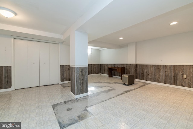 finished basement featuring tile patterned floors, recessed lighting, wooden walls, and wainscoting