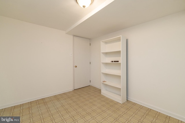 empty room featuring light floors and baseboards