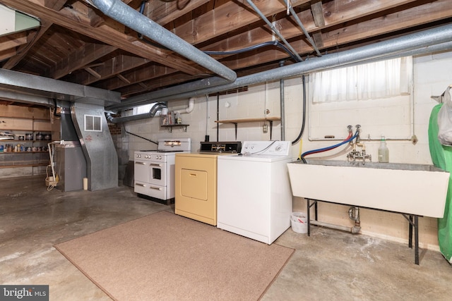 unfinished basement with visible vents, separate washer and dryer, and a sink