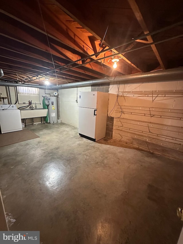 basement with electric water heater, washer / clothes dryer, a sink, and freestanding refrigerator