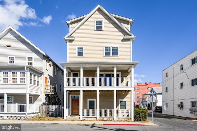 rear view of house featuring a balcony and a porch