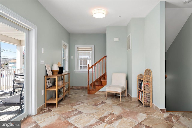 sitting room featuring stone finish floor, baseboards, stairs, and visible vents