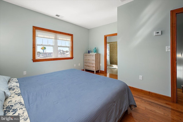 bedroom featuring visible vents and wood finished floors