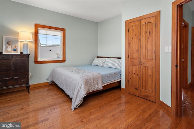 bedroom featuring light wood-style floors and baseboards