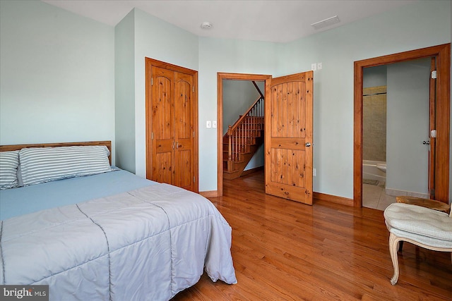 bedroom with baseboards, visible vents, and light wood-style floors