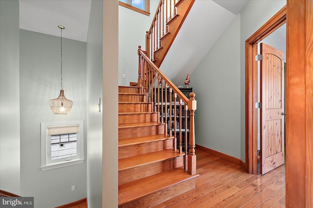 stairway with wood finished floors and baseboards