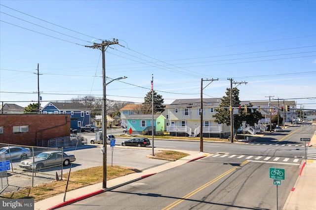 view of street with sidewalks, a residential view, and curbs