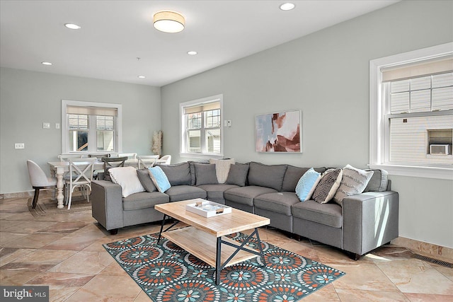 living area with baseboards, visible vents, and recessed lighting