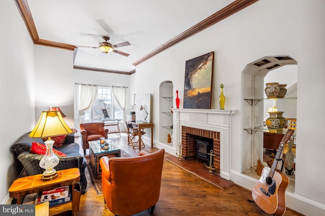 living area with ceiling fan, crown molding, wood finished floors, and baseboards