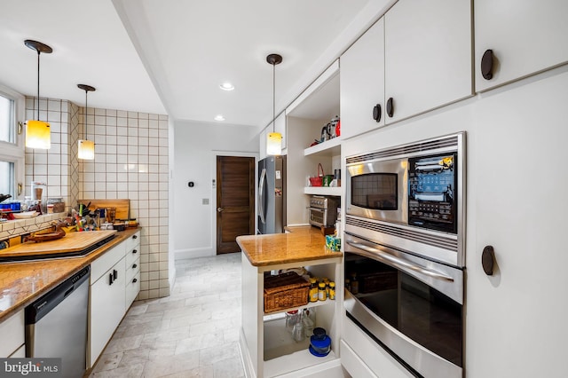 kitchen featuring appliances with stainless steel finishes, white cabinetry, hanging light fixtures, and backsplash