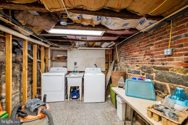 unfinished below grade area featuring brick wall and washer and clothes dryer