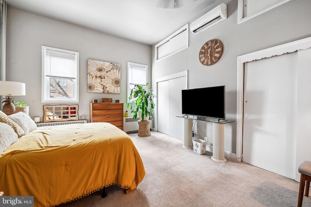 carpeted bedroom featuring radiator heating unit, a wall mounted air conditioner, and multiple closets