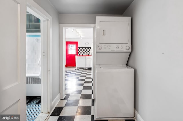 washroom with stacked washer / dryer, radiator, baseboards, and tile patterned floors