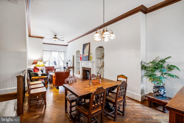 dining space with a brick fireplace, wood finished floors, and crown molding