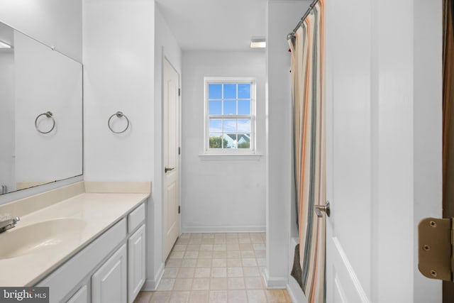 bathroom featuring visible vents, baseboards, a shower with shower curtain, tile patterned floors, and vanity